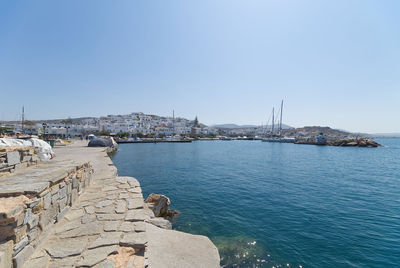 Sailboats by sea against clear blue sky