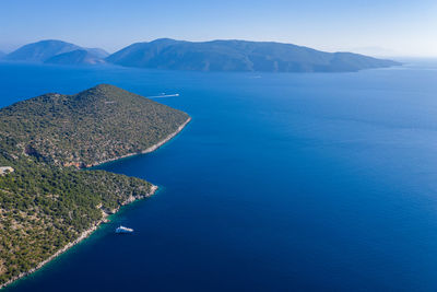 Scenic view of sea and mountains against blue sky