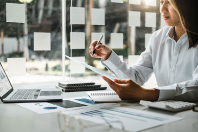 Midsection of businessman working on table