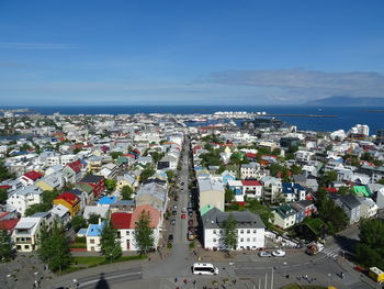 Cityscape by sea against sky