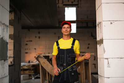 Portrait of young man standing against wall