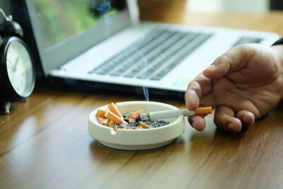 Midsection of person using mobile phone on table