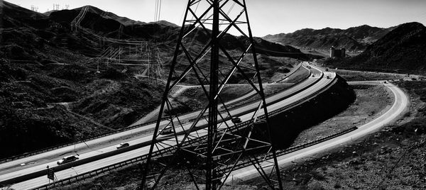 Suspension bridge by mountain against sky