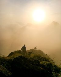 Man on rock against sky