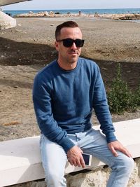 Portrait of man wearing sunglasses sitting outdoors