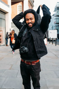 Portrait of smiling young man standing in city