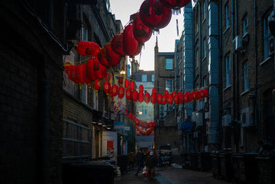 Low angle view of lanterns hanging amidst buildings in city