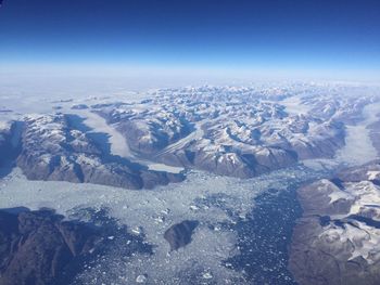 Scenic view of snow covered mountains against blue sky