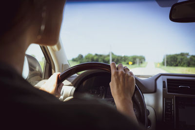 Midsection of man driving car against sky