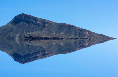 Low angle view of mountain against blue sky
