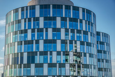 Low angle view of modern building against blue sky