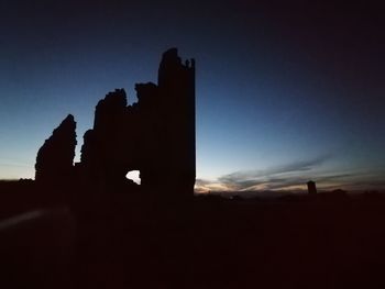 Low angle view of silhouette field against sky during sunset