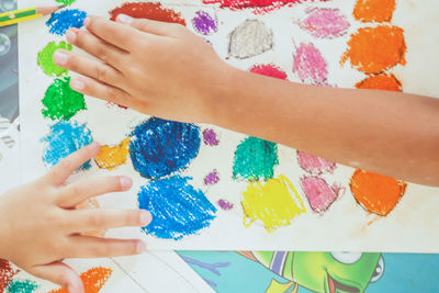 Cropped image of hands over colorful sketch pad