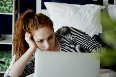 Portrait of young woman using mobile phone at home