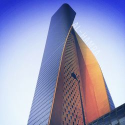 Low angle view of skyscrapers against blue sky