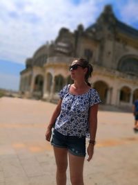 Full length of young woman wearing sunglasses standing outdoors