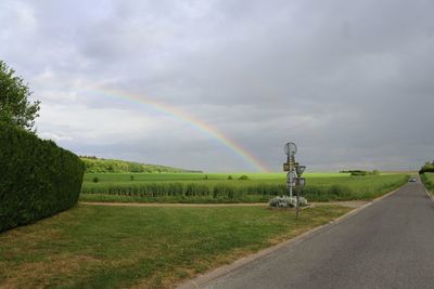 Scenic view of rainbow over road against sky