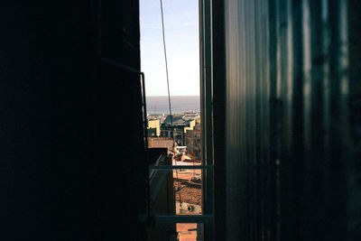 Buildings against clear sky seen through glass window