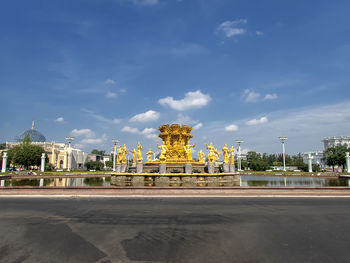 Statue in city against sky