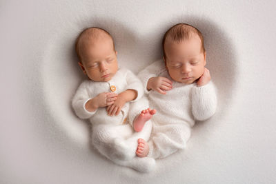 High angle view of babies sleeping on bed