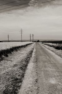Road amidst field against sky