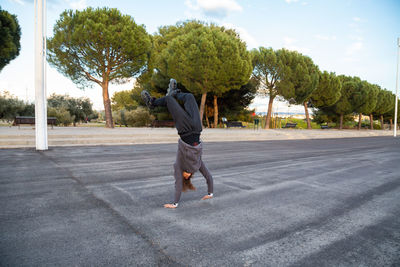 Man doing handstand on road