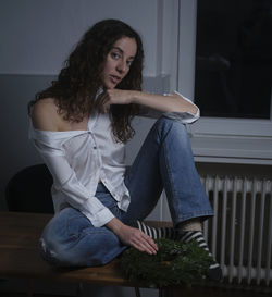 Portrait of woman sitting on table at home