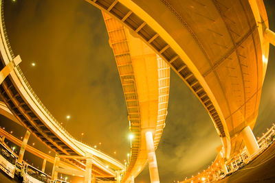 Low angle view of illuminated bridge at night