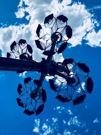 Low angle view of silhouette ferris wheel against blue sky