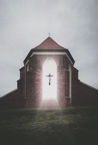 Low angle view of cross against sky