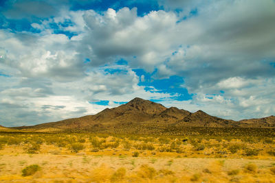 Scenic view of field and mountains against sky