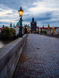 Street amidst buildings in city at dusk