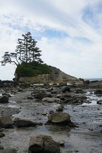 Rock formation by sea against sky