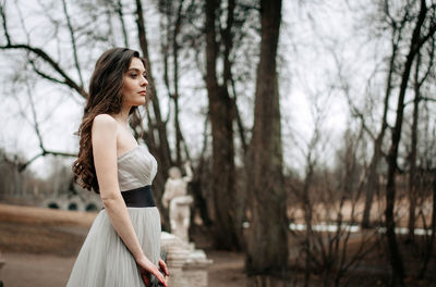 Side view of woman standing in forest