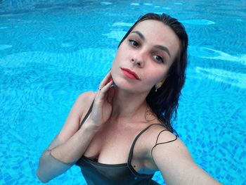 Portrait of young woman swimming in pool