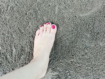 Low section of woman on sand