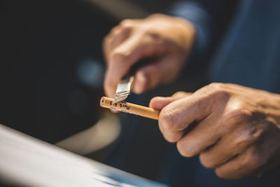 Close-up of hand holding cigarette