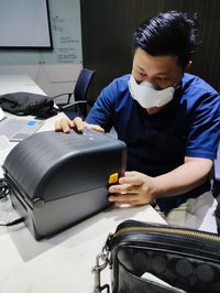 Man using mobile phone while sitting on table