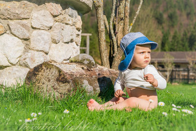 Full length of boy sitting on field