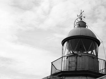 Low angle view of lighthouse by building against sky