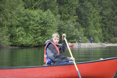 Boy canoeing on lake at wells gray provincial park