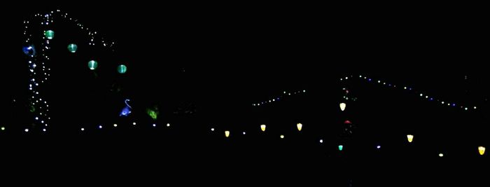 Low angle view of illuminated lighting equipment at night