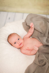 High angle portrait of cute baby lying on bed