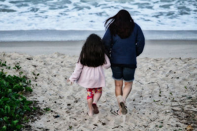 Rear view of women walking on beach