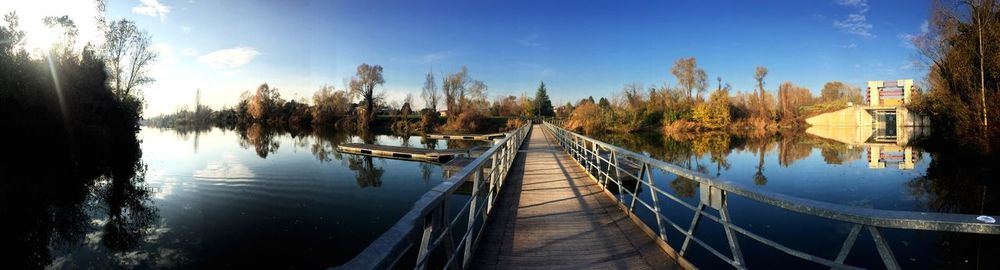 Panoramic view of trees by lake against sky