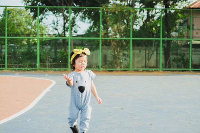 Water spraying on girl walking on tennis court