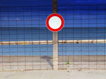 Close-up of information sign against blue wall