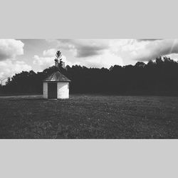 Built structure on landscape against cloudy sky