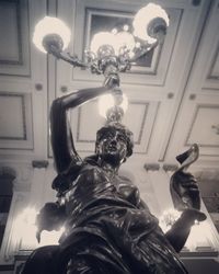 Low angle view of statue of man holding sculpture