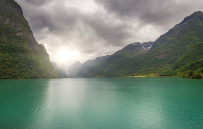 Scenic view of lake by mountains against sky